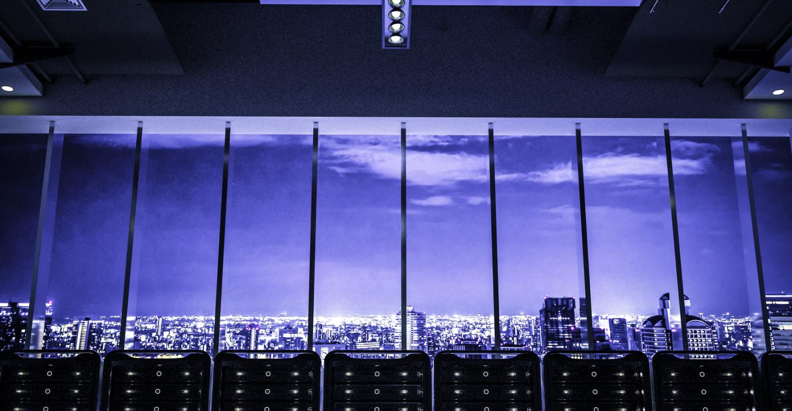 Городской пейзаж с офисными зданиями, сверкающими огнями и современной архитектурой.